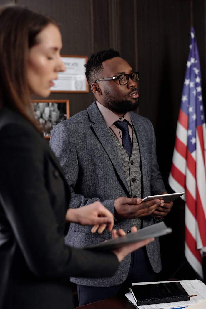 Services Business professionals discussing in an office with American flag backdrop, conveying a diplomatic setting.